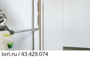 Sealing the opening between the door frame and the wall with mounting foam. Construction and repair. Installation and fastening of a wooden frame. Стоковое видео, видеограф Дмитрий Кобзев / Фотобанк Лори
