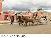 Катание туристы в карете, запряженной двумя лошадьми, по историческому центру Коломны. Россия (2023 год). Редакционное фото, фотограф Наталья Волкова / Фотобанк Лори
