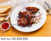 There is plate with cooked lamb barbecue shashlik on wooden table. Pieces of lamb fried on open fire. Стоковое фото, фотограф Яков Филимонов / Фотобанк Лори