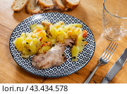 Lunch is served on plate - pieces of young rabbit cooked with segments of potato. Close-up. Стоковое фото, фотограф Яков Филимонов / Фотобанк Лори