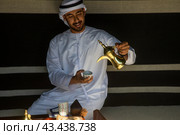 Мужчина наливает в чашку традиционный арабский кофе (2024 год). Редакционное фото, фотограф Николай Винокуров / Фотобанк Лори