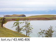 Baikal Lake in summer. Olkhon island. View of peninsula and Kharantsy Island on foggy August day. Mountains on opposite shore of Small Sea are covered with fog and clouds. Natural background. Стоковое фото, фотограф Виктория Катьянова / Фотобанк Лори
