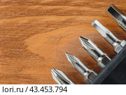 A set of tools collection from heads for screwdriver (bits) on a wooden table with copy space. Flat lay. Corner arrangement. Стоковое фото, фотограф Михаил Строгалев / Фотобанк Лори