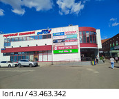 Торговый центр с рекламными вывесками и прохожими, и парковка, Москва, (2024 год). Редакционное фото, фотограф Ирина Терентьева / Фотобанк Лори