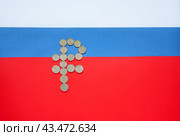 Symbol of Russian currency Ruble consists of ruble coins against background of tricolor of Russian flag. Money and finance concept. Top view, copy space, flat lay, mockup. Стоковое фото, фотограф Виктория Катьянова / Фотобанк Лори