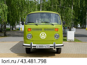 Front view of a green retro Volkswagen Kombi bus (T2) parked on tiles in a park. Cheboksary, Russia. 6/15/2024. Редакционное фото, фотограф Alexander / Фотобанк Лори