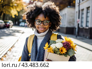 A pretty black African American woman in glasses with a bouquet of autumn flowers goes to school for the first time. A child with a school bag, a book and flowers. A child on a city street. Back to school. Стоковое AI-изображение, AI-художник Photojuli / Фотобанк Лори
