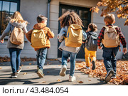 The holiday falls on September 1st. Children with yellow backpacks run to school. Rear view. Back to school. The concept of a new academic year at school. Autumn Knowledge Day. Стоковое AI-изображение, AI-художник Photojuli / Фотобанк Лори