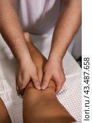 Close-up of relaxing legs massage, masseur therapist doing leg wellness massaging for woman. Suntan lady visit doctor in medical mass clinic office. Rehab relax massage concept. Copy ad text space. Стоковое фото, фотограф Aleksandr Golubev / Фотобанк Лори