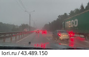 Автомобильное движение в грозу, вид через залитое дождем лобовое стекло автомобиля. Россия, Подмосковье, городской округ Чехов, Симферопольское шоссе (2024 год). Редакционное видео, видеограф Щеголева Ольга / Фотобанк Лори