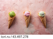 Sweet dessert. Ice cream cones with different flavors on a concrete pink background. World Ice Cream Day. Стоковое AI-изображение, AI-художник Photojuli / Фотобанк Лори