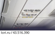 Located buttons and switches on the ceiling of a passenger aircraft, where safety elements such as an oxygen mask are located. With space to copy. Стоковое видео, видеограф Darya Komarova / Фотобанк Лори