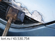 Car body shop. Repair man processes the welding seam using an angle grinder on replaced car part. Professional Body master grind old paint and rust. Rust damage. Rusting car. Hands with tool close-up. Стоковое фото, фотограф Марина Демидюк / Фотобанк Лори
