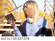 Beautiful caucasian woman with surfing the internet on digital tablet outdoors. Стоковое фото, фотограф Raquel Corcoles Mendez / Фотобанк Лори