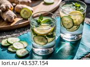 Detoxifying water with cucumber, lemon, lime, ginger and mint for a healthy diet. Стоковое AI-изображение, AI-художник Photojuli / Фотобанк Лори