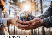 Female and male hands hold a small model of the Earth. Revival. Caring for the planet, ecological awareness and the unity of people in nature conservation. Стоковое AI-изображение, AI-художник Photojuli / Фотобанк Лори