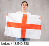 Serious patriotic young female student with flag of England against background of gray wall. Стоковое фото, фотограф Яков Филимонов / Фотобанк Лори
