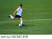 Moscow, Russia, June 2018: Football match, a young player makes a swing before kick the ball (editorial) Редакционное фото, фотограф Михаил Строгалев / Фотобанк Лори
