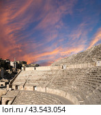 Roman Theatre in Amman, Jordan -- theatre was built the reign of Antonius Pius (138-161 CE), the large and steeply raked structure could seat about 6000 people. Against the sky with clouds (2016 год). Стоковое фото, фотограф Владимир Журавлев / Фотобанк Лори