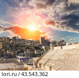 Roman Theatre in Amman, Jordan -- theatre was built the reign of Antonius Pius (138-161 CE), the large and steeply raked structure could seat about 6000 people. Against the sky with clouds (2016 год). Стоковое фото, фотограф Владимир Журавлев / Фотобанк Лори