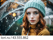 Autumn portrait in the rain. Close-up of a young red-haired woman with expressive green eyes in a knitted hat under an umbrella. Стоковое AI-изображение, AI-художник Photojuli / Фотобанк Лори