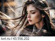 A beautiful, young woman with a thoughtful look. The hair develops in the wind and gives a feeling of lightness and naturalness. Стоковое AI-изображение, AI-художник Photojuli / Фотобанк Лори