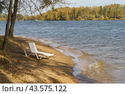 Touristic resort near Istra water Reservoir in day. Holidays concept. Photography of one lounger at the beach near the water. Domestic Russian tourism. Summer holidays are finishing. Стоковое фото, фотограф YuryKara / Фотобанк Лори