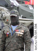 Москва военный в орденах на выставке подбитой военной техники во время проведения СВО на Украине (2024 год). Редакционное фото, фотограф Дмитрий Неумоин / Фотобанк Лори
