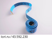 A blue measuring tape on a white background in the form of a question mark. Стоковое фото, фотограф Ярославский Максим / Фотобанк Лори