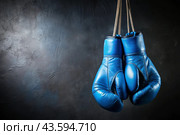 Professional blue boxing gloves hang on a black background with a space to copy. Стоковое AI-изображение, AI-художник Photojuli / Фотобанк Лори