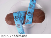 The eclair cake is wrapped with measuring tape. Стоковое фото, фотограф Ярославский Максим / Фотобанк Лори