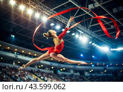 Rhythmic gymnastics is a close-up of a beautiful gymnast with a ribbon in the center of attention in a sports arena. An Olympic sport. Стоковое AI-изображение, AI-художник Photojuli / Фотобанк Лори