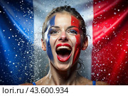 A beautiful athlete or cheerleader from France with joyful shouts after winning the competition at the Olympic Games against the background of the French flag. Стоковое AI-изображение, AI-художник Photojuli / Фотобанк Лори