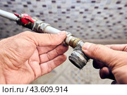 Crimp collet compression fitting angle with transition to an external thread in hands of plumber that eliminates leaks. Стоковое фото, фотограф Владимир Григорьев / Фотобанк Лори