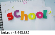 A mysterious and inspiring vision of the letters that form the word SCHOOL falling on an open notebook. Стоковое AI-видео, аниматор Юрий Поздников / Фотобанк Лори