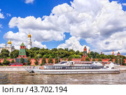 Прогулочный кораблик Рэдиссон и Кремль и красный автобус, Москва-река, Москва (2024 год). Редакционное фото, фотограф Baturina Yuliya / Фотобанк Лори