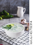 Tzatziki sauce with cucumber, garlic and dill on kefir in a bowl on the table vertical view. Стоковое фото, фотограф Елена Руй / Фотобанк Лори