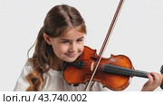 A girl joyfully plays a beautiful violin against a plain white background, highlighting her talent. Стоковое AI-видео, аниматор Юрий Поздников / Фотобанк Лори