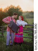 Photo of a young couple in Russian folk costumes and accordion. Стоковое фото, фотограф Elena Kosinova / Фотобанк Лори