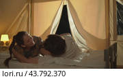 Lovers enjoy each other's company in nature. They snuggle together on the bed in the campsite. Стоковое видео, видеограф Strunov David / Фотобанк Лори