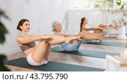 Three generation of women perform sitting lightweight variation of boat pose Paripurna Navasana. Стоковое фото, фотограф Яков Филимонов / Фотобанк Лори