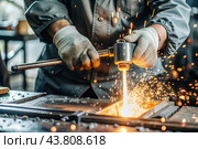 Work at the factory. Working professions. Men's hands in protective gloves with metal. There are sparks around. Hard work that requires high concentration and professionalism. Стоковое AI-изображение, AI-художник Photojuli / Фотобанк Лори