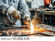 Work at the factory. Working professions. Men's hands in protective gloves with metal. There are sparks around. Hard work that requires high concentration and professionalism. Стоковое AI-изображение, AI-художник Photojuli / Фотобанк Лори