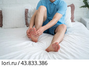 Foot pain, corns and calluses, dry skin on legs, man suffering from feet ache at home. Стоковое фото, фотограф Станислав Тарко / Фотобанк Лори