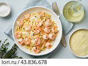 Pasta bavette with fried shrimps, bechamel sauce, thyme on blue table, top view, italian cuisine. Стоковое фото, фотограф Natalia Gdovskaia / Фотобанк Лори
