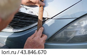 Car body shop. Repair man processes the welding seam using an angle grinder on replaced car part. Professional Body master grind old paint and rust. Rust damage. Rusting car. Hands with tool close-up. Стоковое видео, видеограф Марина Демидюк / Фотобанк Лори