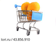 Three ripe yellow apricots in a shopping cart on a white background. The concept of buying fresh fruits. Стоковое фото, фотограф Ярославский Максим / Фотобанк Лори