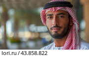 Portrait of a Young Emirati Man in Traditional Attire at a Modern Urban Location. Стоковое AI-изображение, AI-художник Сергей Толмачёв / Фотобанк Лори