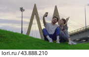 After couples, students relax in the park. A young man, while taking a selfie, accidentally drops his phone. Стоковое видео, видеограф Strunov David / Фотобанк Лори