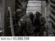 Отряд военных в камуфляже выстроилась за солдатом с бронещитом и пистолетом. Штурм. (2020 год). Редакционное фото, фотограф Евгений Зимин / Фотобанк Лори